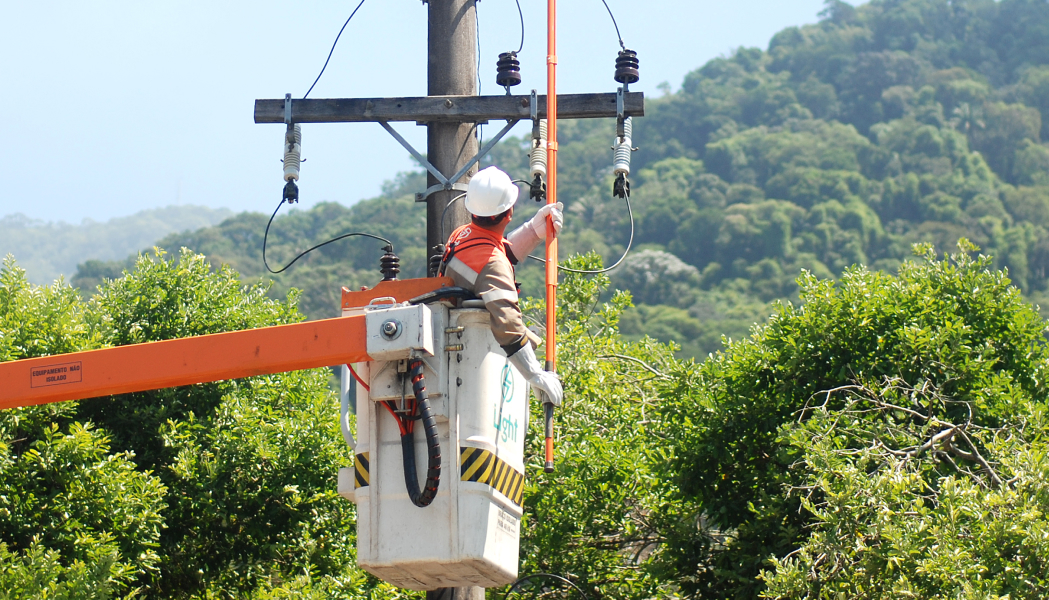 Homem mexendo nos postes de luz.