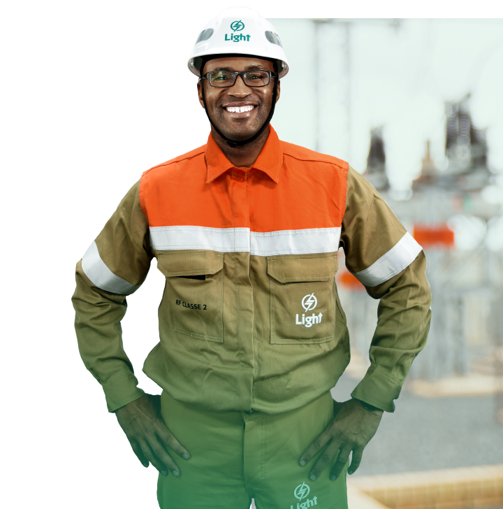 Homem sorrindo com as mãos na cintura vestindo o uniforme da Light.
